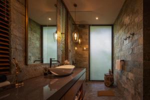 a bathroom with a sink and a mirror at Munduk Cabins in Munduk +86 photos