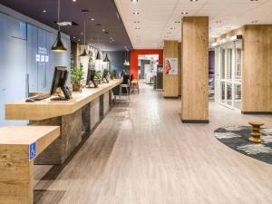 a lobby of a store with a counter and chairs at ibis Recife Aeroporto in Recife