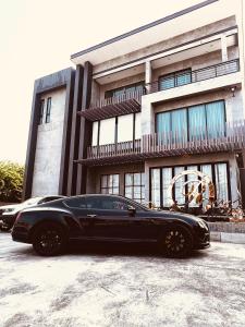 a black car parked in front of a building at LECAR Home Mustang in Ban Nong Khang