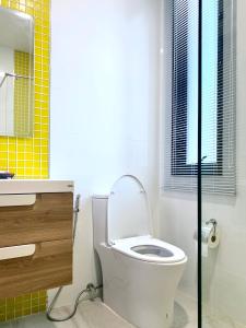 a bathroom with a toilet and a sink and a window at LECAR Home Mustang in Ban Nong Khang