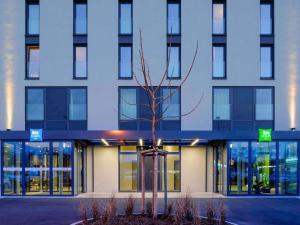 a building with a tree in front of it at Ibis Styles Konstanz in Konstanz