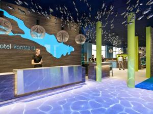 a woman standing in front of a lobby at Ibis Styles Konstanz in Konstanz