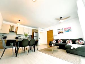 a living room and kitchen with a couch and a table at Estrella Garden Condos con Vista a la piscina in San Rafael del Yuma