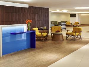 a waiting room with a blue counter and chairs at Novotel Rio de Janeiro Parque Olimpico in Rio de Janeiro