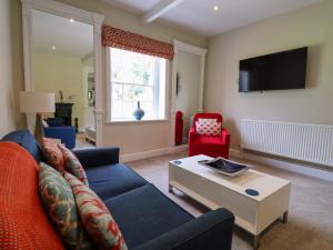 a living room with a blue couch and a table at South Tower Cottage in Macclesfield