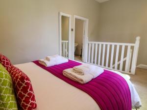 a bedroom with a bed with two towels on it at South Tower Cottage in Macclesfield