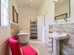 a bathroom with a red chair and a sink at South Tower Cottage in Macclesfield +42 photos