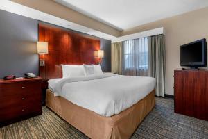 a hotel room with a large bed and a flat screen tv at Residence Inn by Marriott Columbus in Columbus