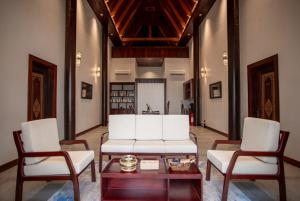 a living room with two white chairs and a table at Koh Totung Resort in Kaoh Sdach