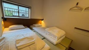 two twin beds in a room with a window at New open - ねどことあさげナマケモノ Nedoko & Asage by Sloth - Japanese Traditional House in Ōno +38 photos