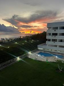 a view of a building with a sunset in the background at Vista mar nascente in São Luís