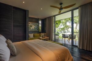 a bedroom with a large bed with a ceiling fan at Munduk Cabins in Munduk