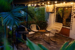 a patio with chairs and a table and lights at Le”More House in Girardot