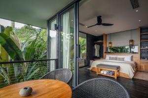 a bedroom with a bed and a glass wall at Munduk Cabins in Munduk