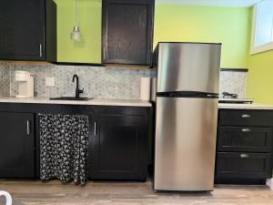 a stainless steel refrigerator in a kitchen with black cabinets at Sunset Suite in Bridgewater +4 photos