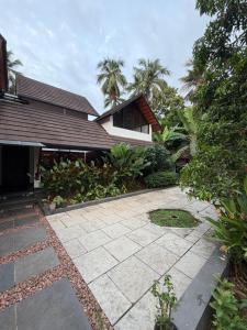 a house with a stone walkway in front of a house at Bodhi nila private villa in Irimbranallūr