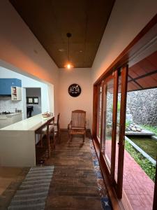 a kitchen and dining room with a table and chairs at Bodhi nila private villa in Irimbranallūr