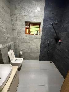 a bathroom with a toilet and a sink at Bodhi nila private villa in Irimbranallūr