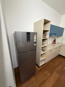a kitchen with a stainless steel refrigerator next to a shelf at Bodhi nila private villa in Irimbranallūr +12 photos