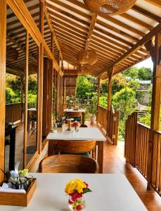 a wooden covered porch with a table and chairs at Mirabelle Joglo Village in Karimunjawa