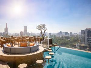 a hotel with a pool with a view of the city at Hotel Des Arts Saigon Mgallery Collection in Ho Chi Minh City