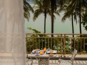 a table with food on a balcony with palm trees at Koh Totung Resort in Kaoh Sdach