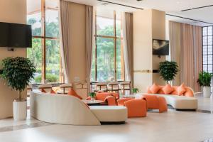 a lobby with orange and white furniture and windows at Long Hotel in Danang