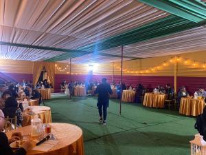 a man walking on a stage in a room with tables at Hotel Miramar in Huarmey +114 photos