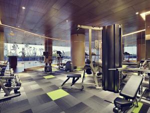 a gym with treadmills and machines in a building at Mercure Karawang in Karawang