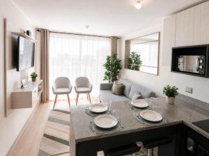 a kitchen and living room with a table and a couch at Nuevo departamento cercano a playa y comercio in Viña del Mar