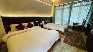 a bedroom with two beds and a window with a chair at Hotel Dhulikhel View Point in Dhulikhel +7 photos