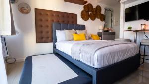 a bedroom with a large blue bed with yellow pillows at KL Tower Luxury Boutique Hotel Studio Fast WiFi Resort Swimming Pool Sauna & Gym in Manila +17 photos