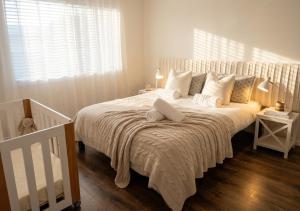 a bedroom with a large white bed with white pillows at 100m to Beach&Shop Spacious Pristine One Story Family Home in Batemans Bay +31 photos