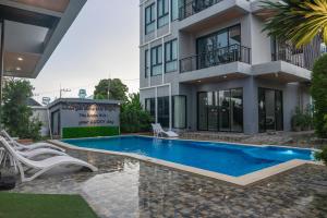 a swimming pool in front of a building at The Lucky Beach Ao Nang in Ao Nang Beach