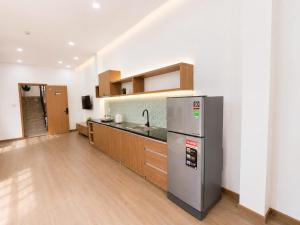 a kitchen with a stainless steel refrigerator and wooden cabinets at Min Sweet Home 2 in Danang