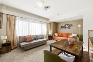 a living room with a couch and a table at Stylish 2-Bed Stay with Pool & Parking in Canberra