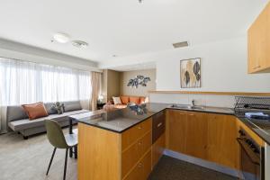 a kitchen and living room with a couch at Stylish 2-Bed Stay with Pool & Parking in Canberra
