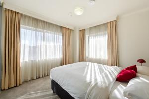 a bedroom with a large bed and two windows at Stylish 2-Bed Stay with Pool & Parking in Canberra +18 photos