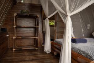 a bedroom with a bed with a canopy at Vertical House Bali in Uluwatu