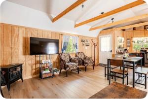 a living room with a television and a table and chairs at Serenity Cabin - Cozy Mountain retreat near Shenandoah National Park in Luray