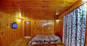 a bedroom with a bed in a wooden room at Pine inn in Pahalgām