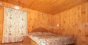 a bedroom with a bed in a wooden room at Pine inn in Pahalgām