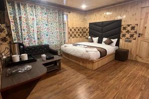 a bedroom with a king sized bed and a couch at Pine inn in Pahalgām