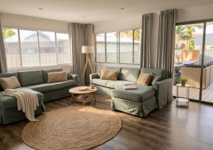 a living room with two couches and a rug at 100m to Beach&Shop Spacious Pristine One Story Family Home in Batemans Bay