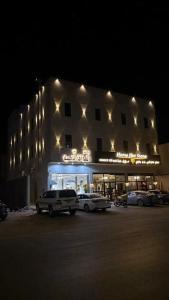 a building with cars parked in front of it at night at نُزل البدر - غرفة و صالة دخول ذاتي in Al Kharj