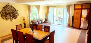a dining room with a table and a couch at Luxury Beachfront SeaView Apartment in Ko Chang