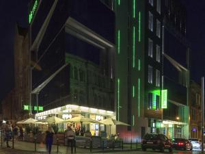a building with umbrellas on a city street at night at Ibis Styles Lviv Center in Lviv