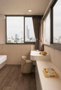 a bathroom with a tub and a sink and windows at The Cozy Hotel in Ho Chi Minh City +173 photos