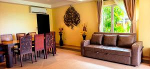a living room with a couch and a table and chairs at Luxury Beachfront SeaView Apartment in Ko Chang