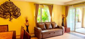 a living room with a leather couch and a window at Luxury Beachfront SeaView Apartment in Ko Chang